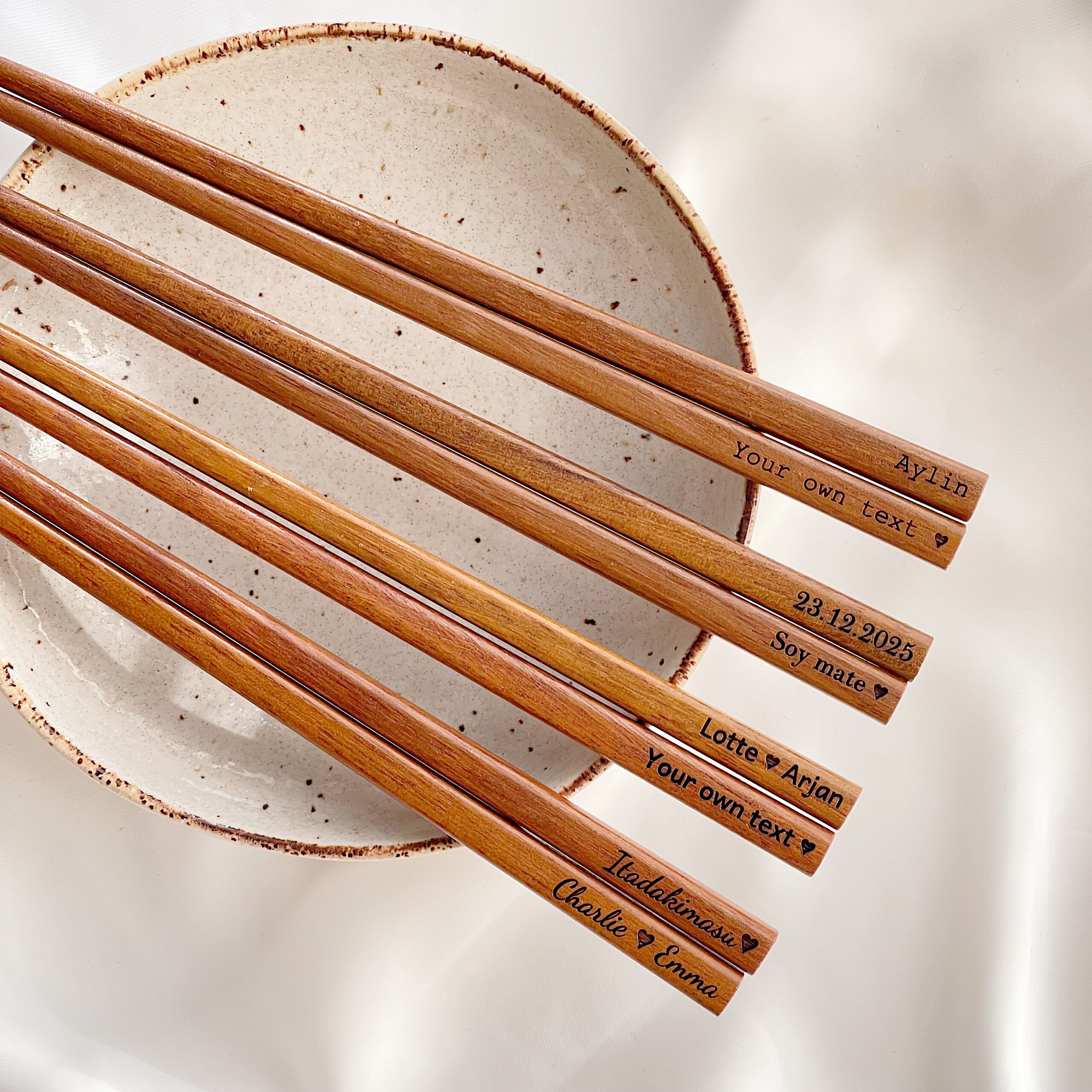 Gravures in verschillende lettertypes op houten japanse eetstokjes